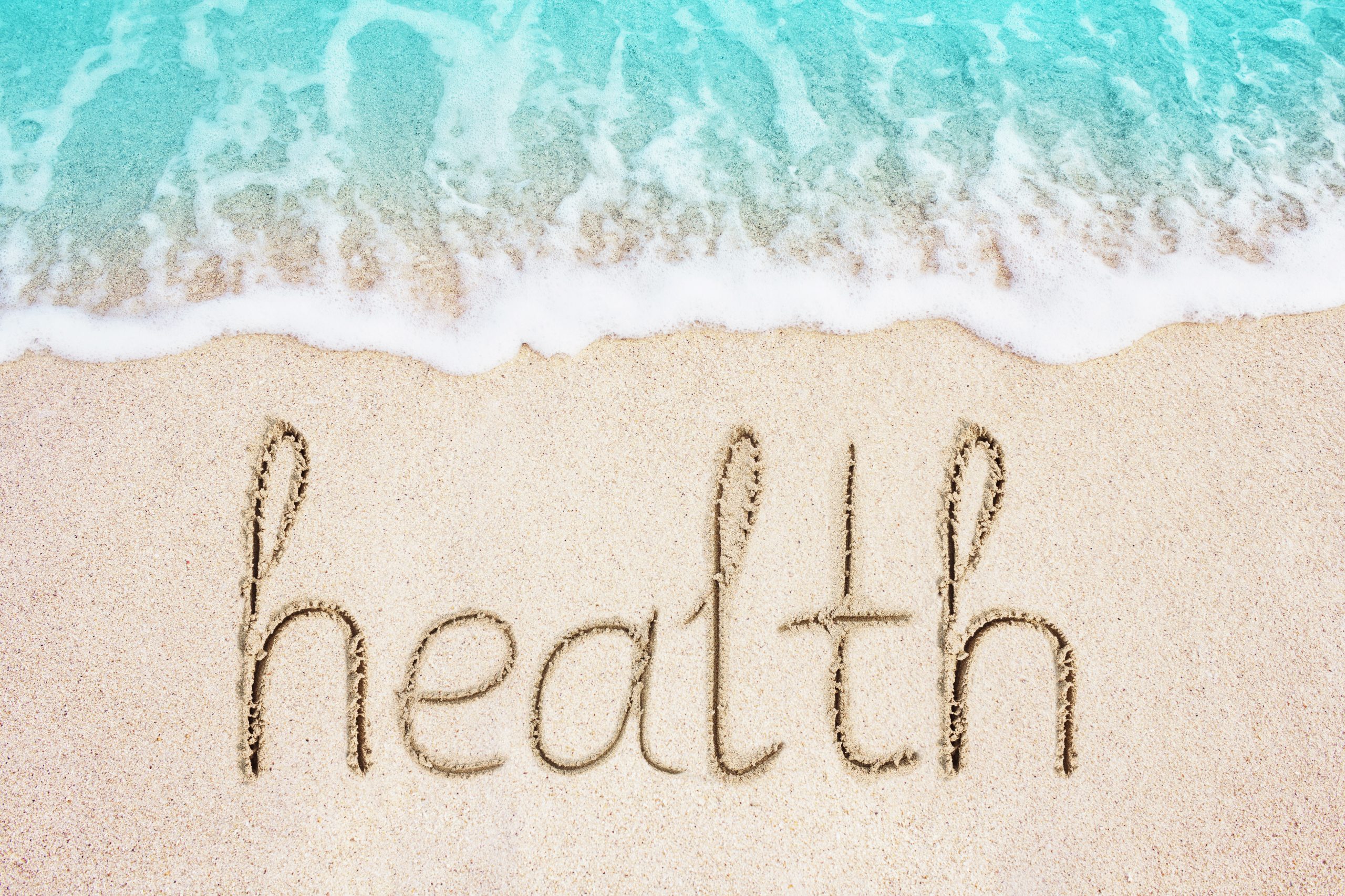 Website beach theme of Health written in sand depicts Our Health Services
